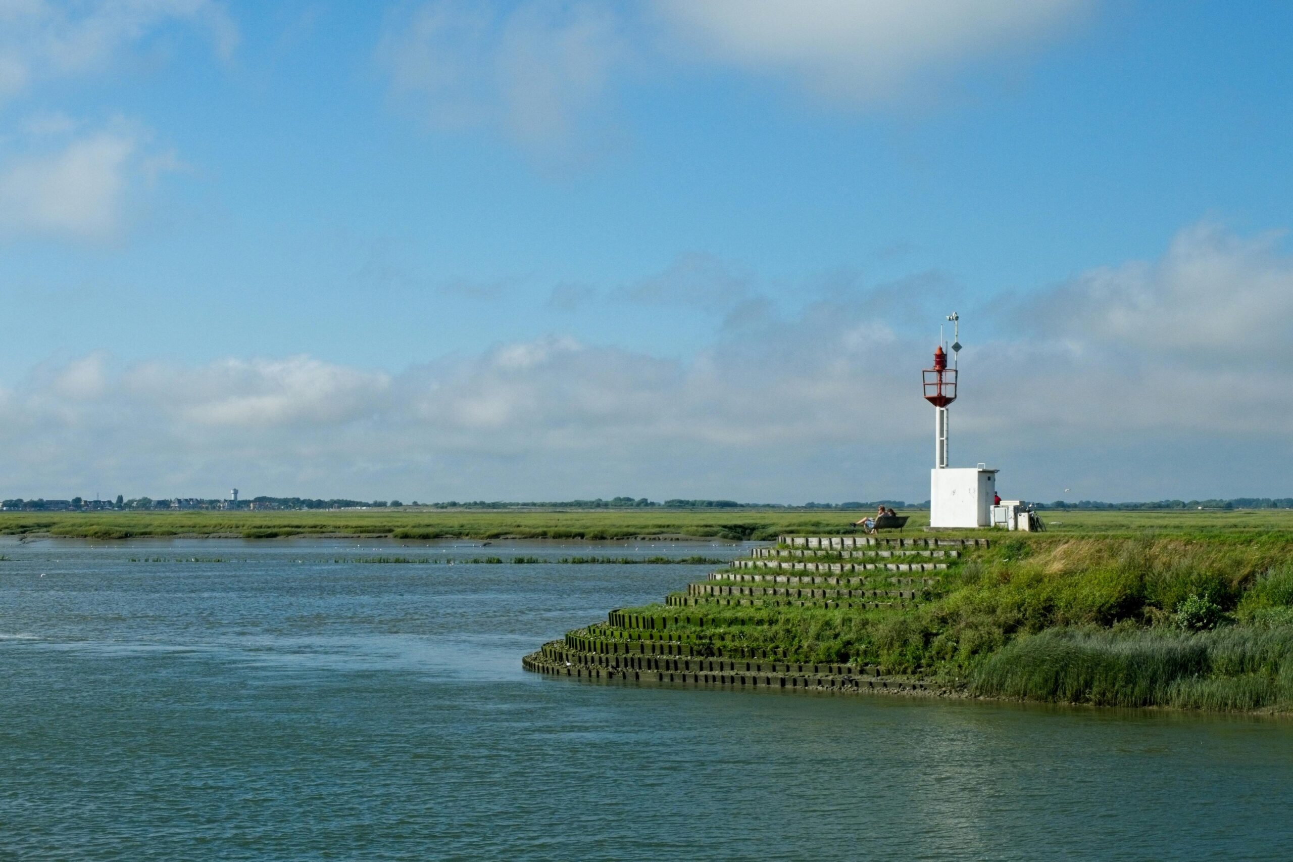 Serene estuary scene featuring a beacon tower against a blue sky, perfect for relaxation.